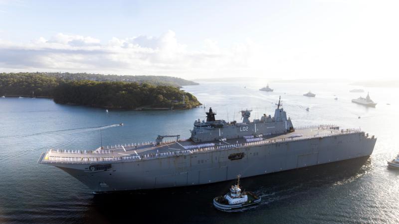 The Ship's Company of HMAS Canberra line the upper decks, followed by JS Kumano, FNS Auguste Benebig, HMAS Brisbane and Guardian-class Patrol Boat HMPNGS Francis Agwi as they sail past Bradley's Head for the Exercise Kakadu Fleet Review.