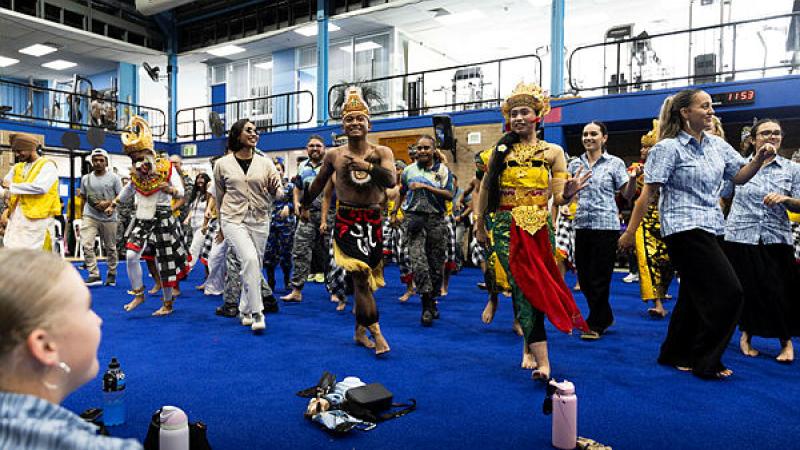 People in colourful and traditional costumes perform dance routines to a crowd.