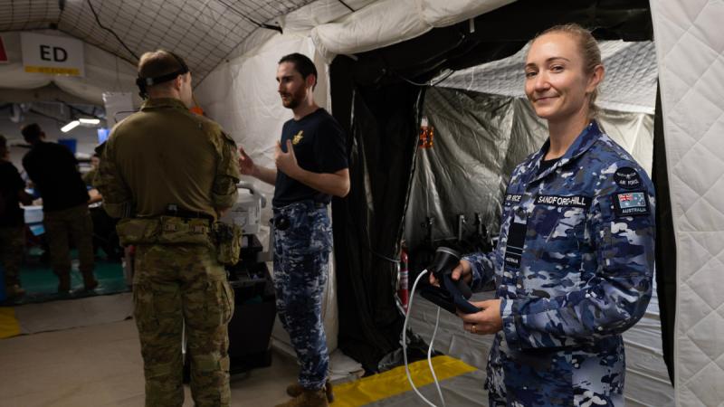 Air Force nursing officer stands outside canvas medical tent during excercise VIPER WALK 26.