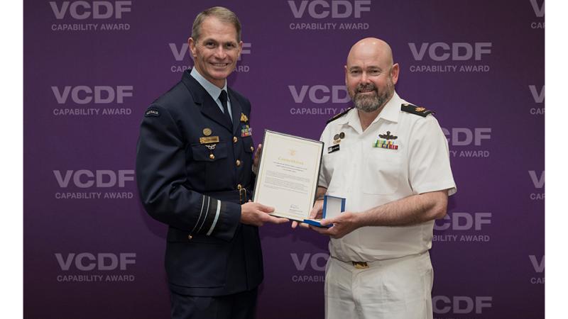 Two military men present an award. 
