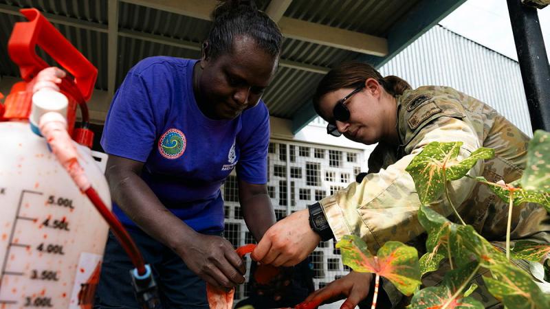 A Solomon Islands person and an Australian Army member tend to a mock casualty.