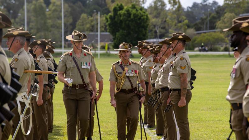 Two Army leaders walk through a group of soldiers on parade at Gallipoli Barracks.