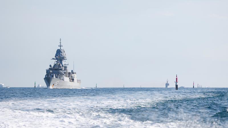 An Australian navy ship in the foreground and a Malaysian ship in the background sailing during an excercice