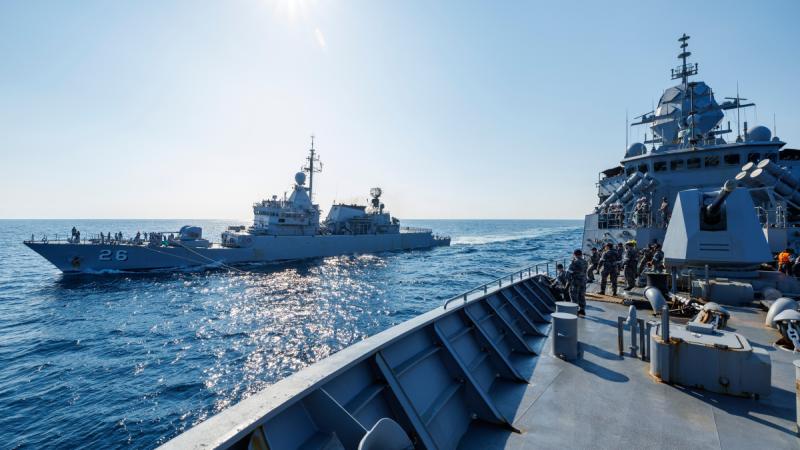 Two warships sailing close together at sea.