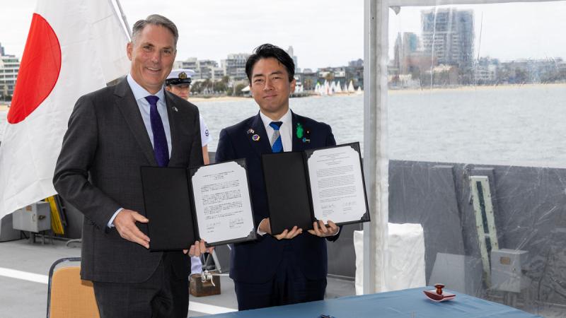 Deputy Prime Minister and Minister for Defence, the Hon. Richard Marles, MP and Minister of Defense for Japan, Koizumi Shinjiro, hold the contracts onboard Japanese Ship Kumano after signing the 'Mogami Memorandum'.