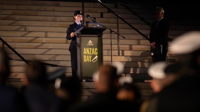 A woman in Air Force uniform speaks at a lectern. 