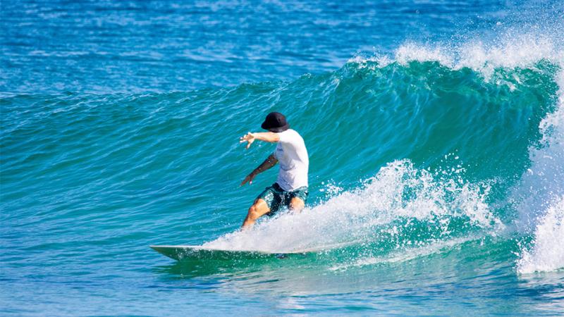 A man surfs a wave in the ocean.
