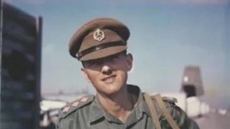 A young man in Australian Army uniform standing outdoors. 