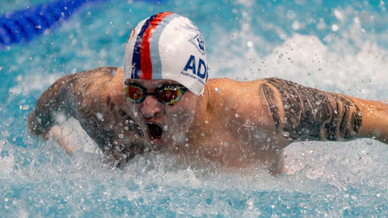A man emerges from the water during a butterfly pool event.