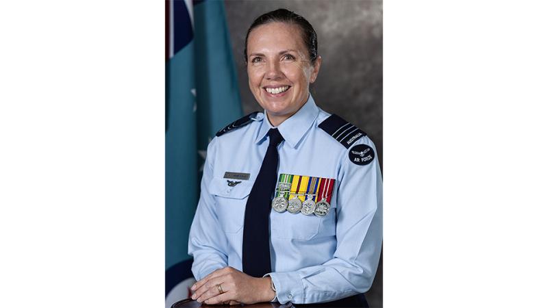 A woman in military uniform poses for a photo.