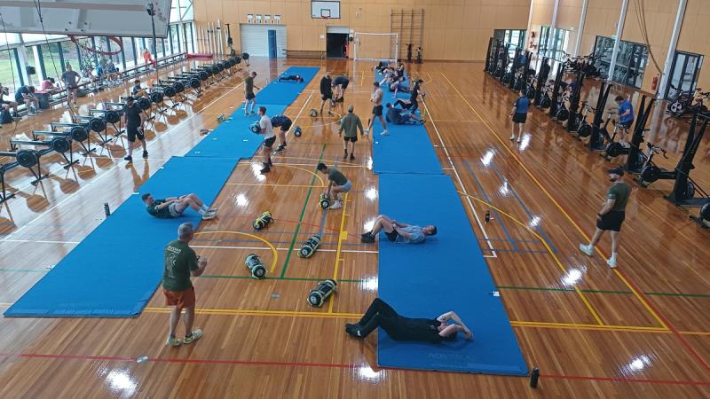 A group of people doing a workout in a gym.