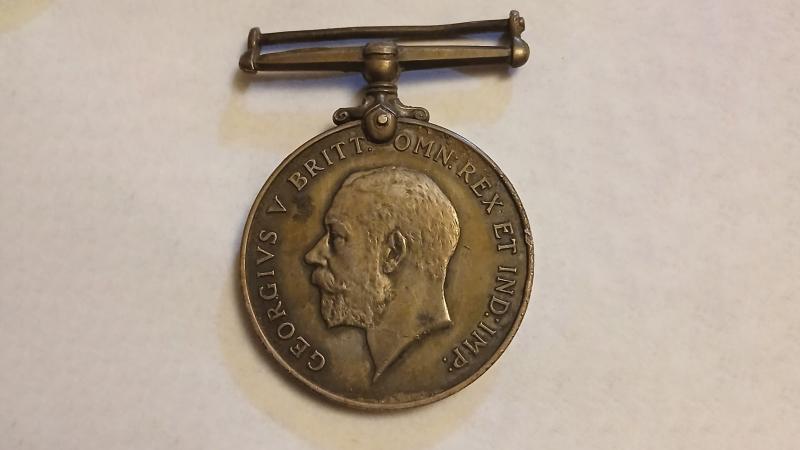 A medal bearing the profile of King George V and Latin script.
