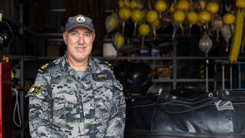A man standing in Navy uniform.