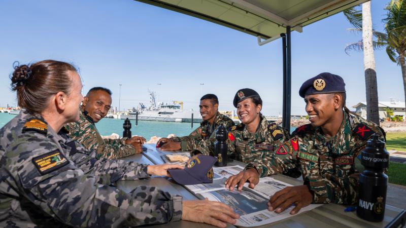 A group of military personnel sitting around a table.