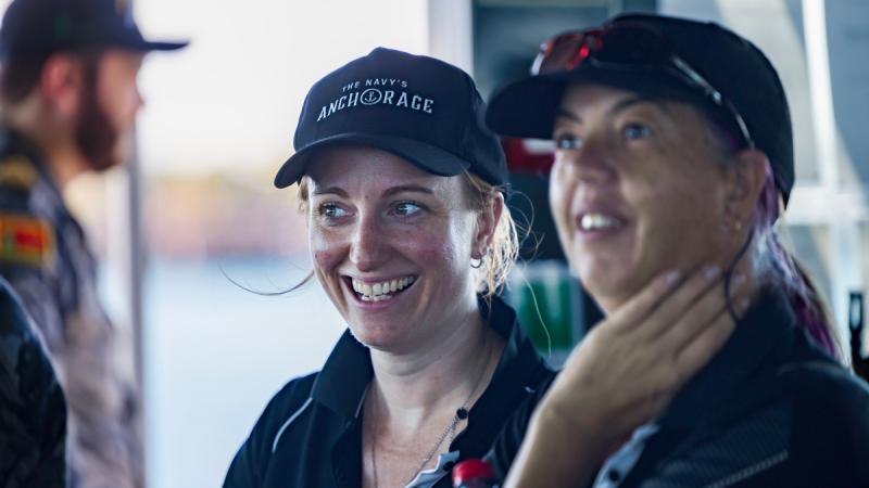 Two women wearing caps on board a Navy ship.