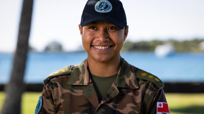 A female Tongan Army member poses for a portrait photo outdoors.