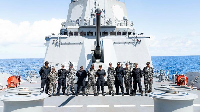 Australian and New Zealand sailors stand together on an Australian Navy ship.