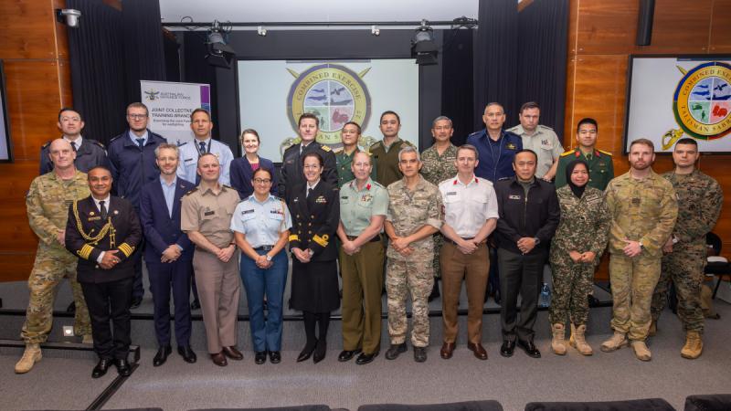 A group of international military personnel stand together.