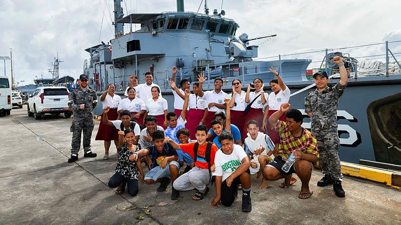 A big group of students celebrate after a grand tour of HMAS Diamantina.