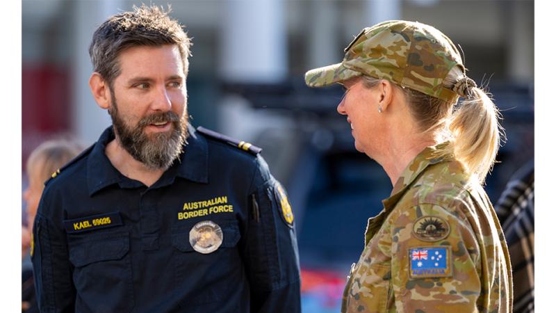 A military member and an Australian Border Force member engage in conversation.