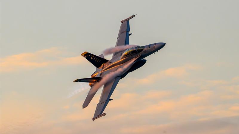 An aircraft in flight at sunset.