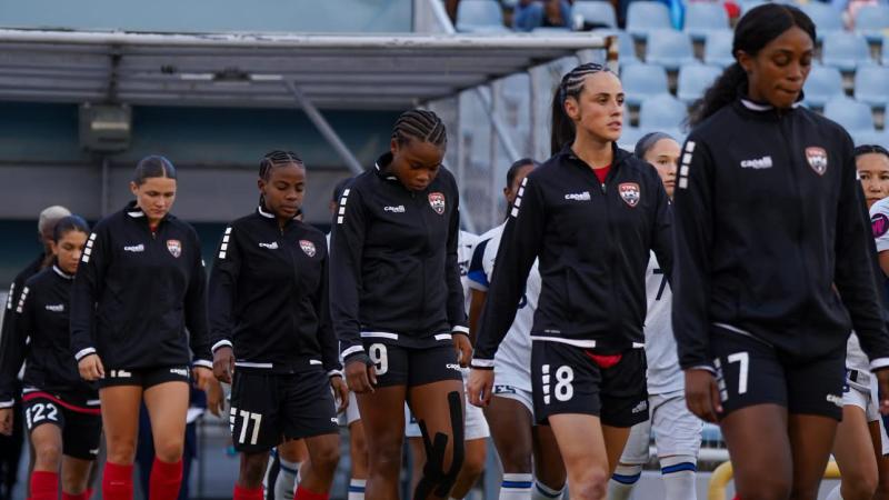 A line of women in athleisure walks out into a stadium.