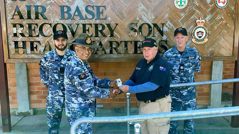 Two men shaking hands with two other men standing next to them.