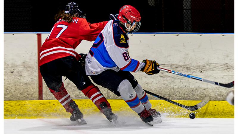 Two ice hockey players compete during a game.