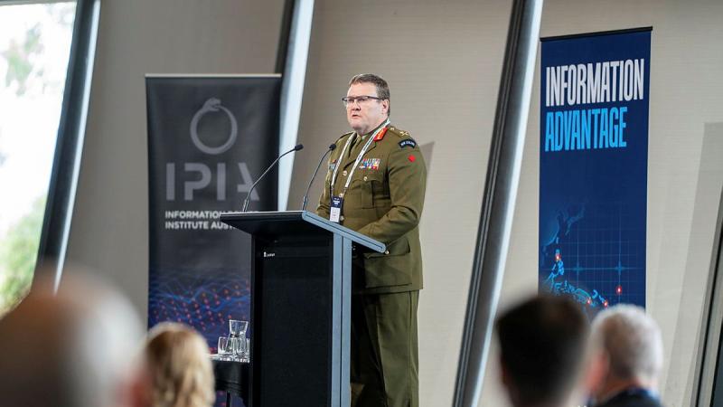 An Army leader stands at a podium and delivers a speech to an audience.