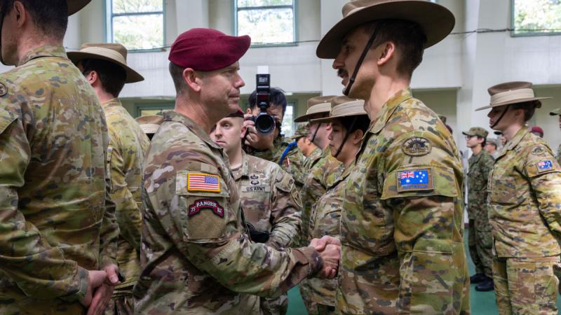 Australian Army officer Captain Lewis Mikulic stands on parade and shakes hands with United States Army 11th Airborne Division Commander, Major General John P. Cogbill during Exercise Yama Sakura 91 closing ceremony.