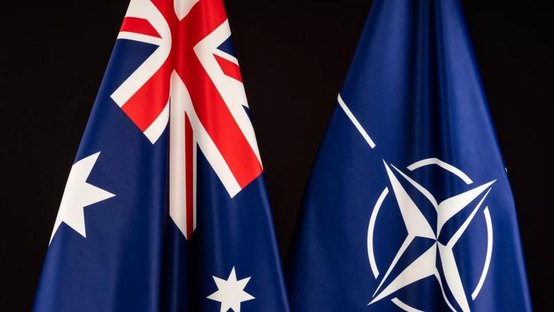 A photo of two flags, one of which is the Australian National Flag.