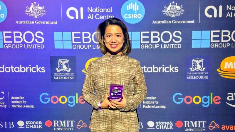 A woman standing holding an award.
